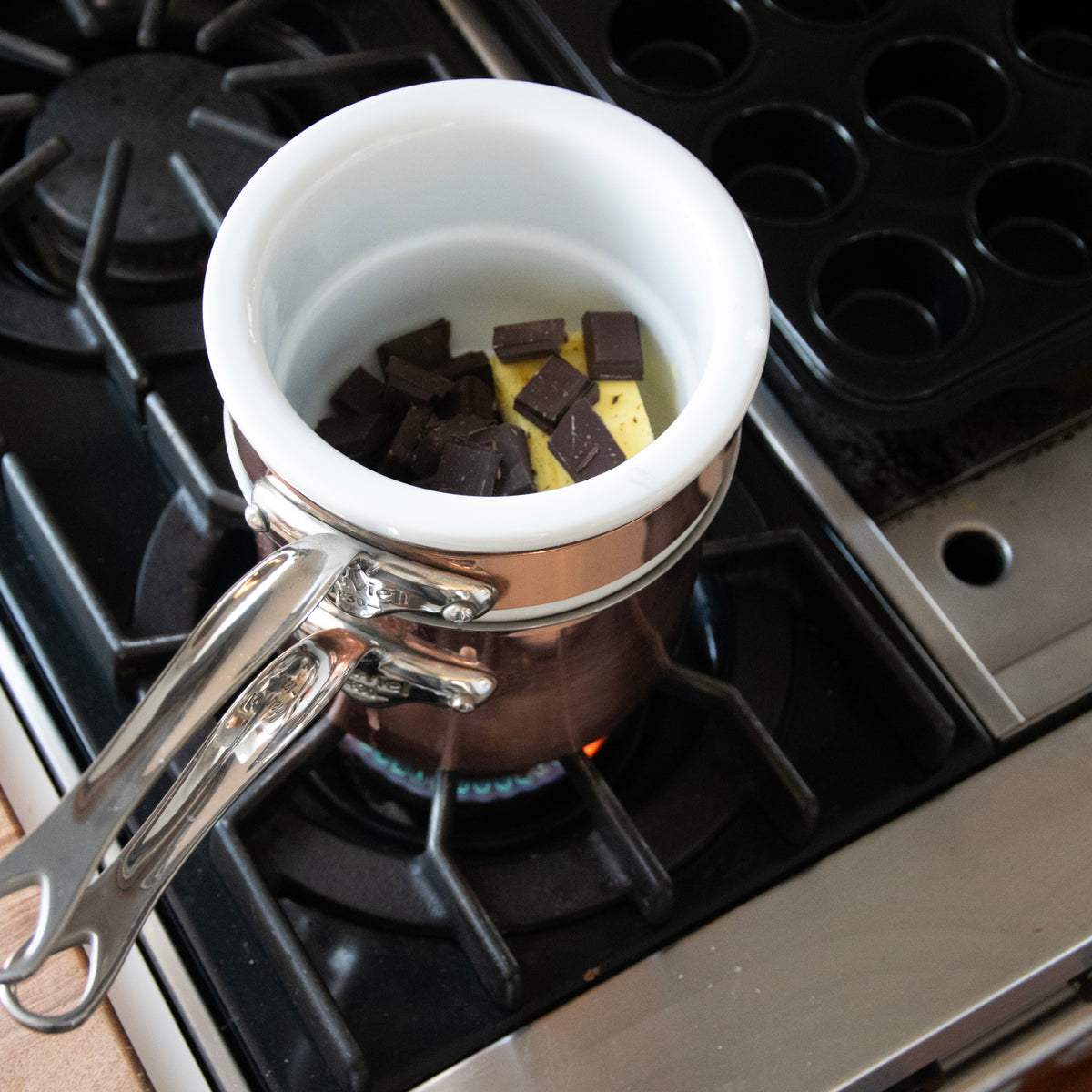 Mauviel copper tinned double boiler with stainless steel handles and lid, 0.9-quart capacity, used for gentle heating and melting.