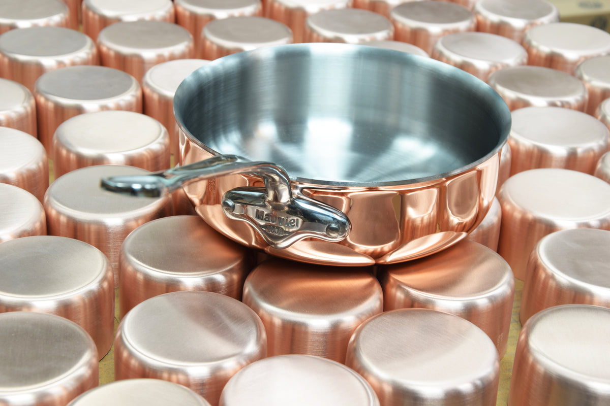 Copper blanks and a finished sauté pan at the Villedieu workshop