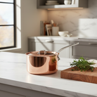 Mauviel M'3 S copper sauce pan with lid and cast stainless steel handle, showcasing a polished copper exterior and sturdy lid.
