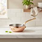 Mauviel M'Heritage M'150 B copper chef pan with brass handle, showcasing a shiny copper cooking surface and sturdy handle.